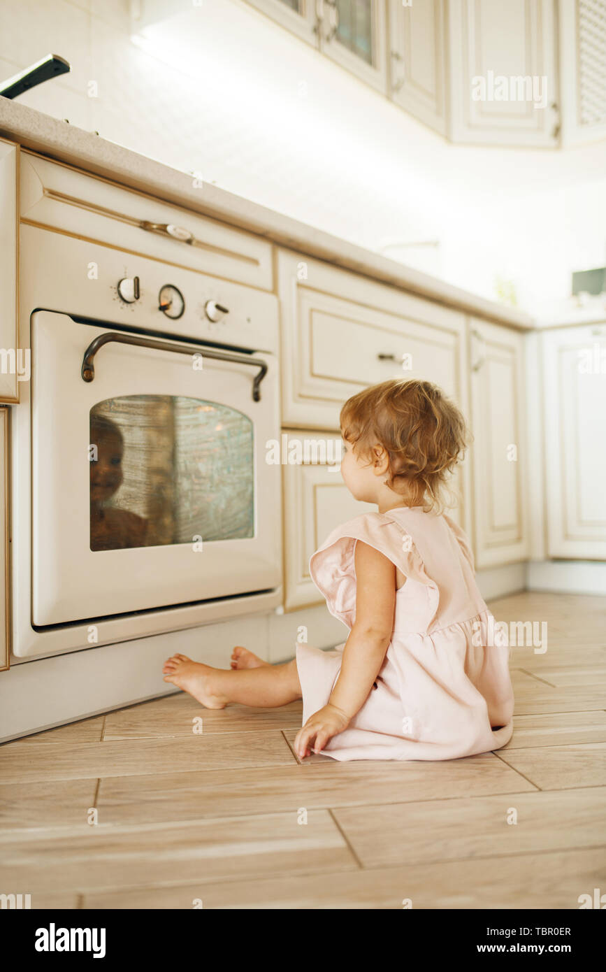 Femme enfant assis sur le plancher à la four Banque D'Images