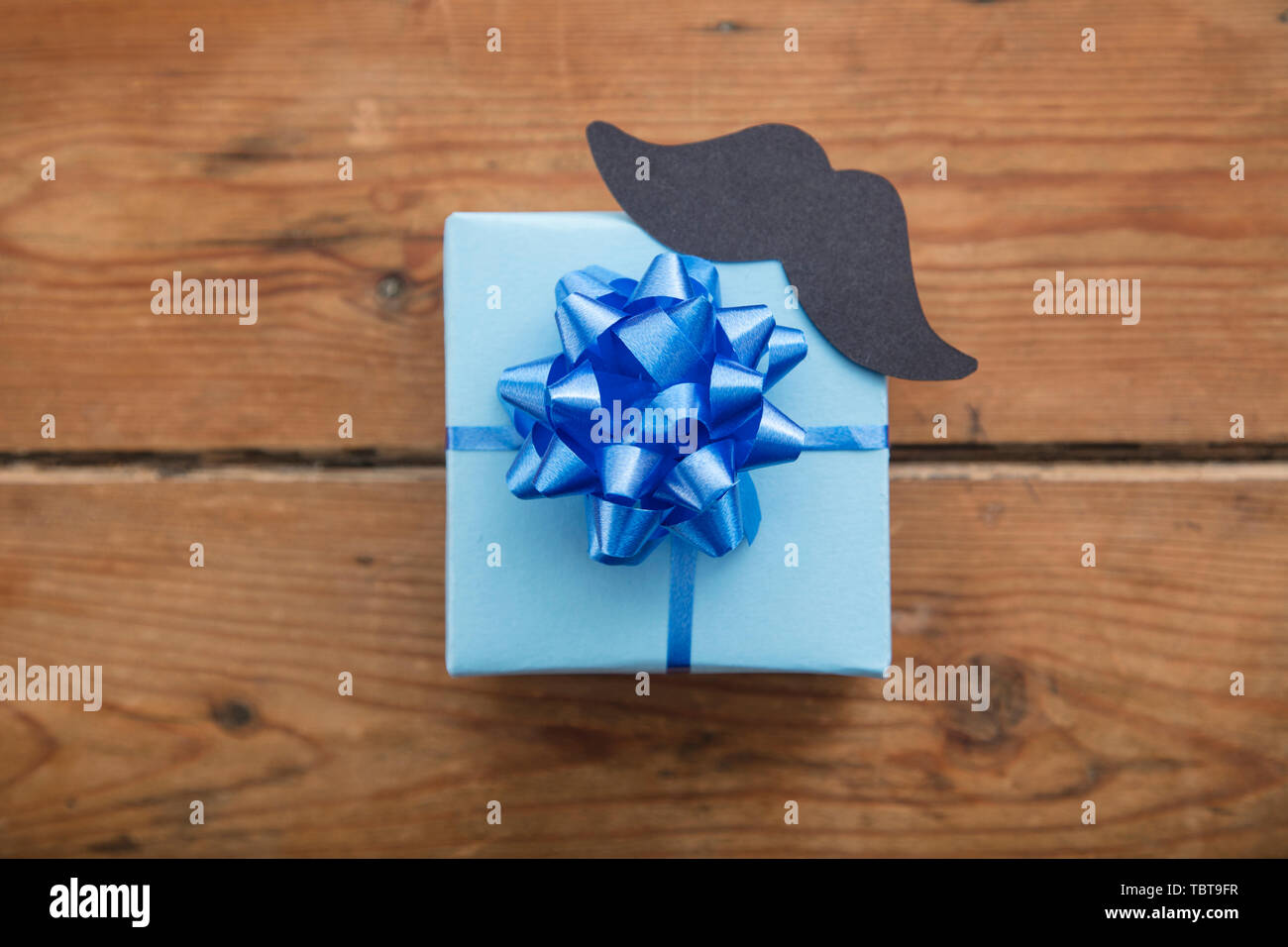 Des pères cadeaux enveloppés de papier bleu avec moustache. Happy father's day background Banque D'Images