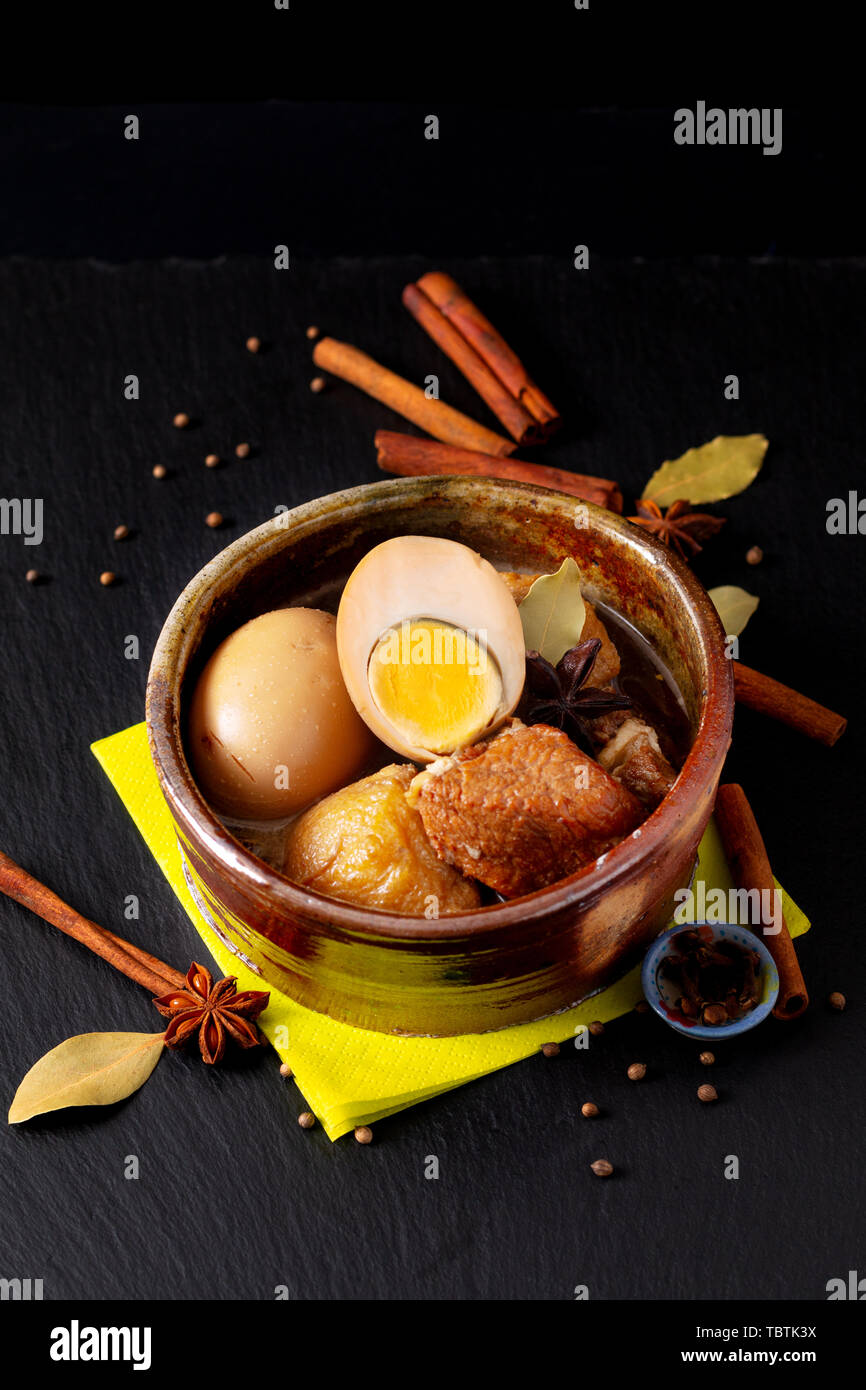 Concept alimentaire Thai cuisine flan de porc et des oeufs avec 5 épices ragoût parfumé Palo Moo sur black slate board with copy space Banque D'Images