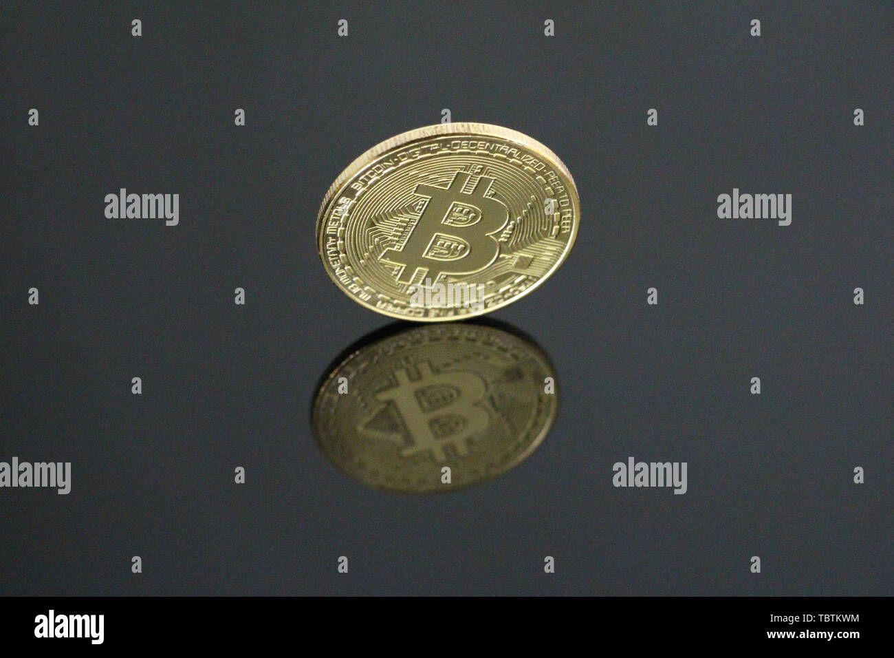Une pièce d'or sur fond noir bitcoin. Bitcoin est sur le côté. On peut voir son reflet. Concept Cryptocurrency bitcoin gold. Aucun peuple, vide Banque D'Images