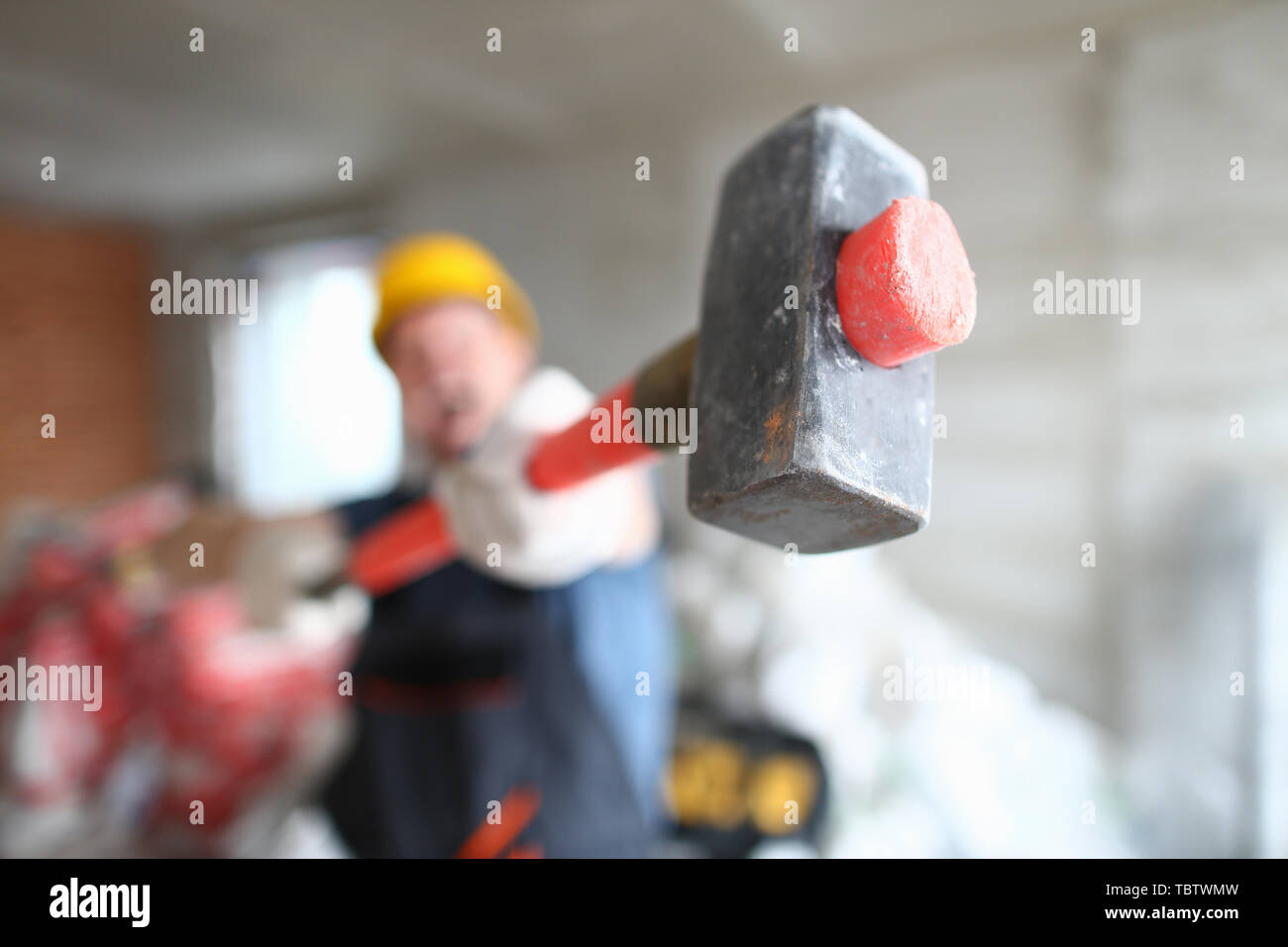 L'accent sur le rouge sledgehammer artisan l'aide d'équipements spéciaux pour détruire et changement construction site afin d'améliorer et de permettre une meilleure apparence. Buil Banque D'Images