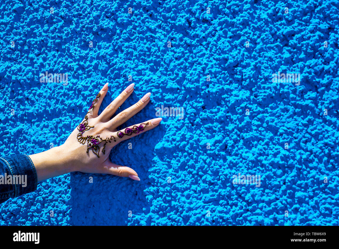 Bras avec un tatouage au henné traditionnel sur l'arrière-plan de la mur bleu. Rabat, Maroc. Afrique du Sud Banque D'Images