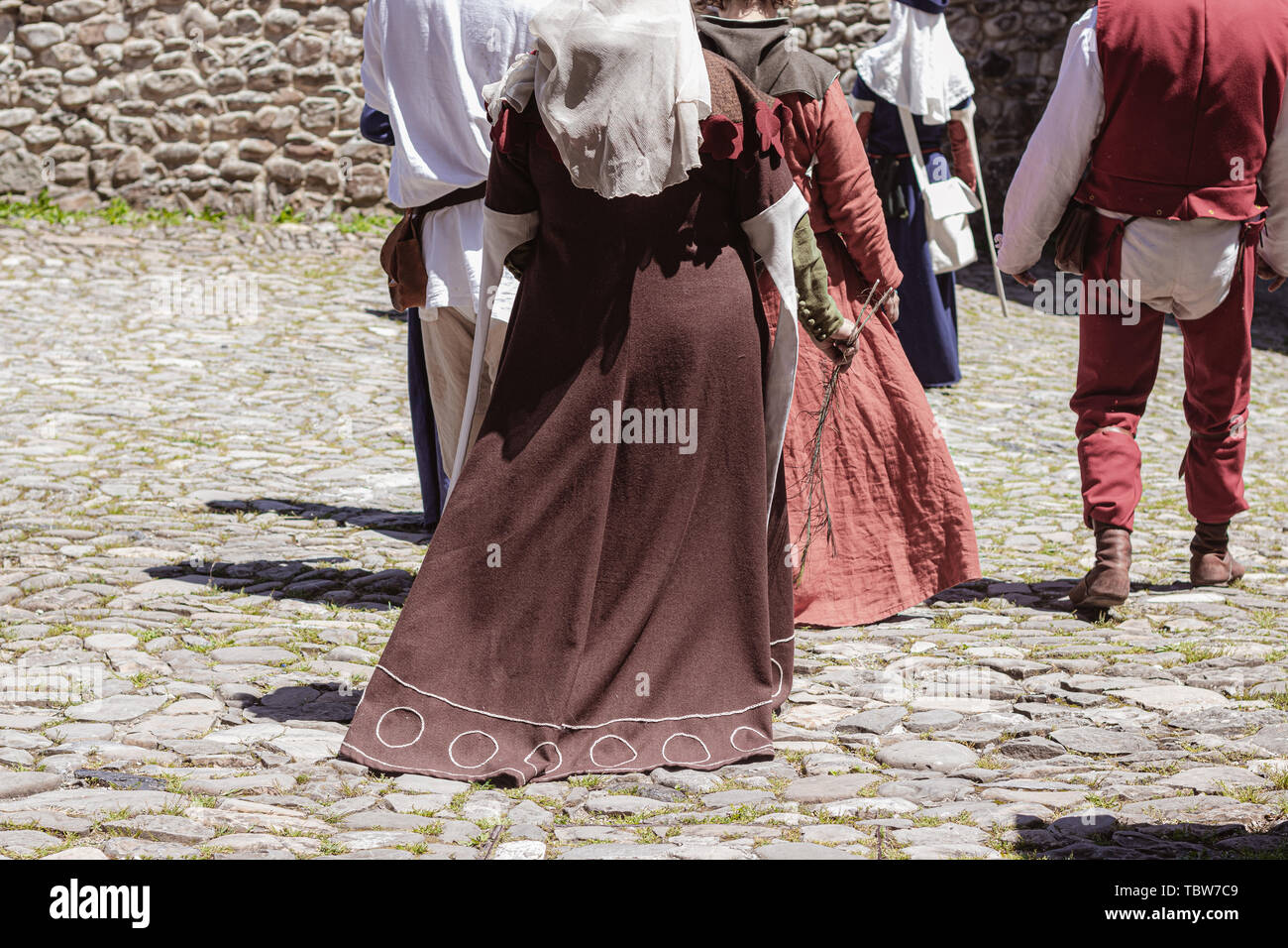 Groupe d'méconnaissable gens habillés en costumes médiévaux marchant dans une rue ancienne Banque D'Images