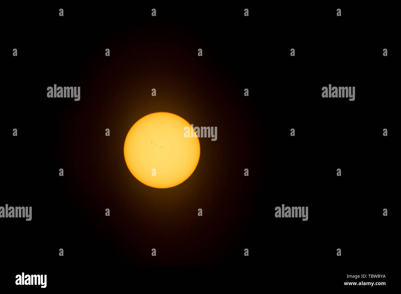 Image du soleil téléobjectif prises à travers un filtre de protection de la lumière révélant les taches sur la surface du soleil. Banque D'Images