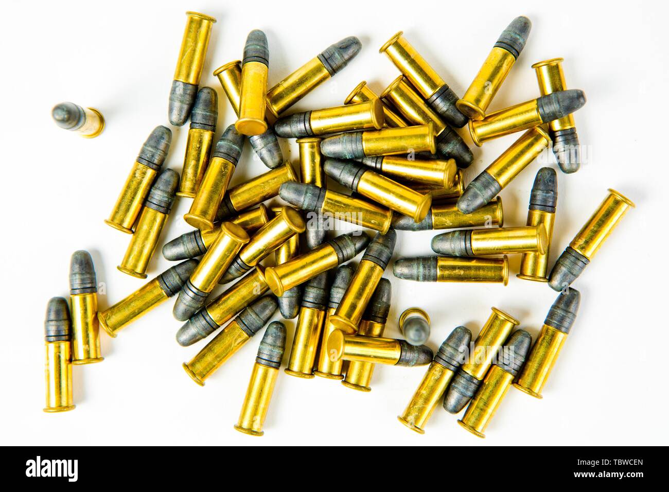 Bande de petits rim fire munitions, laiton jaune et gris plomb sur fond blanc Banque D'Images