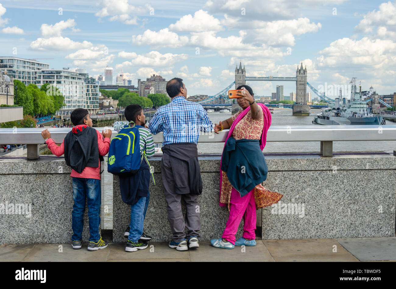 Une famille asiatique visiter Londres et prendre un avec la Tamise selfies et le Tower Bridge en arrière-plan. Banque D'Images