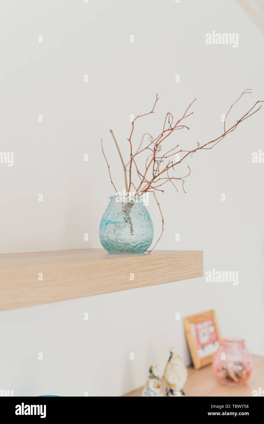 Durée de lumière sur le mur avec décor. Une branche dans un vase. Le minimalisme scandinave dans l'intérieur. Banque D'Images