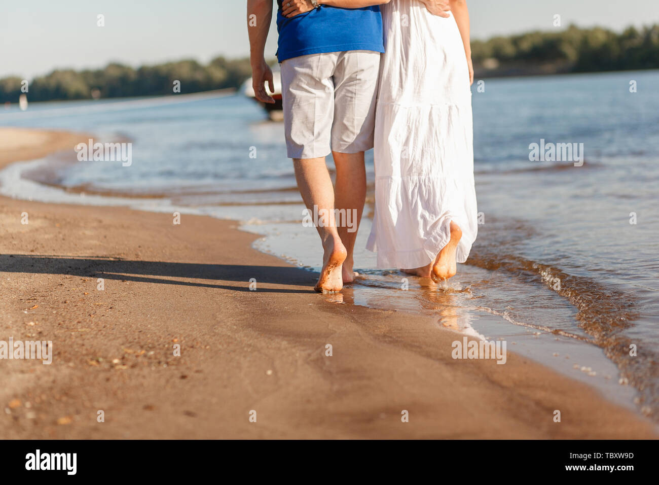 Les pieds dans l'eau l'été. Jeune couple en train de marcher pieds nus le  long de la plage. Histoire d'amour. Les vagues et le sable. Concept de  reste Photo Stock - Alamy