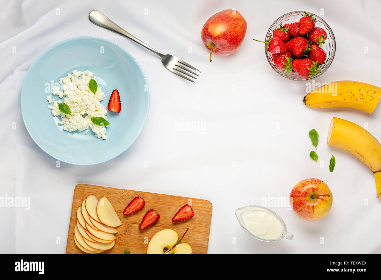 Healthy dessert à la crème, avec des fraises, des pommes et du fromage cottage sur une nappe blanche. Vue de dessus. Espace Cpoy Banque D'Images