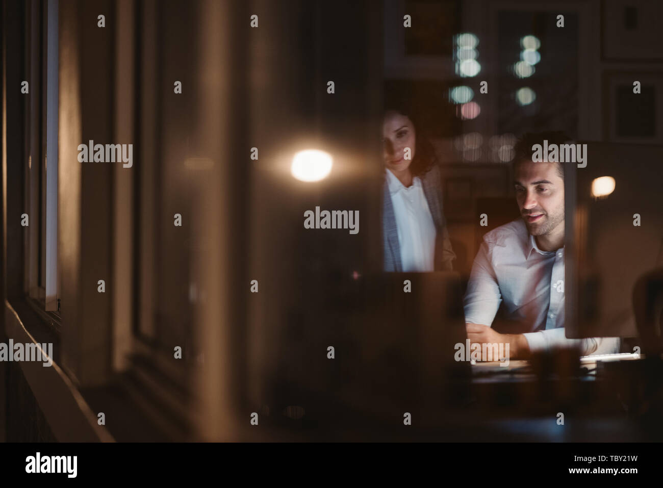 Des collègues qui travaillent ensemble à l'intérieur d'un bureau tard dans la nuit Banque D'Images