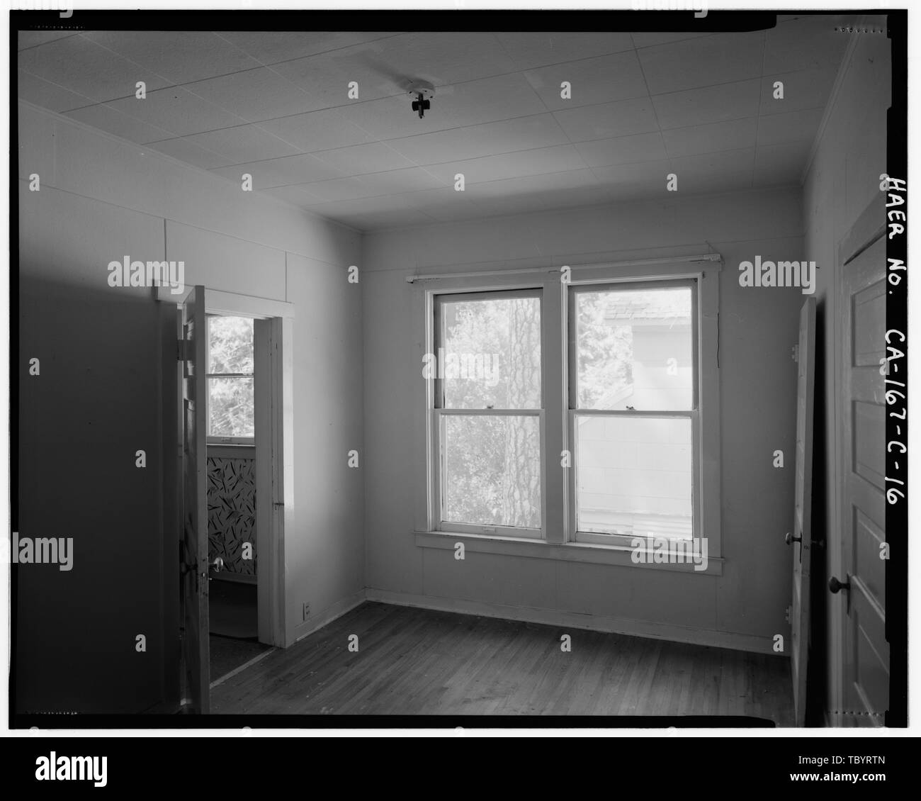 Chambre nord montrant l'intérieur OUVRIR LA PORTE D'une salle de bains privative à gauche de la photo, deux 1 SUR 1 DOUBLEHUNG LA LUMIÈRE, les habitations à WINDOWS DANS UN ARRANGEMENT LIÉ AU CENTRE DE LA PHOTO, ET LA PORTE FERMÉE DE LA CUISINE À DROITE DE LA PHOTO. Vue de l'Ouest. Système hydroélectrique du ruisseau Big, Big Creek Town, maison de l'opérateur, l'Avenue du Verger au sud de Lac de Huntington Road, Big Creek, comté de Fresno, CA Banque D'Images