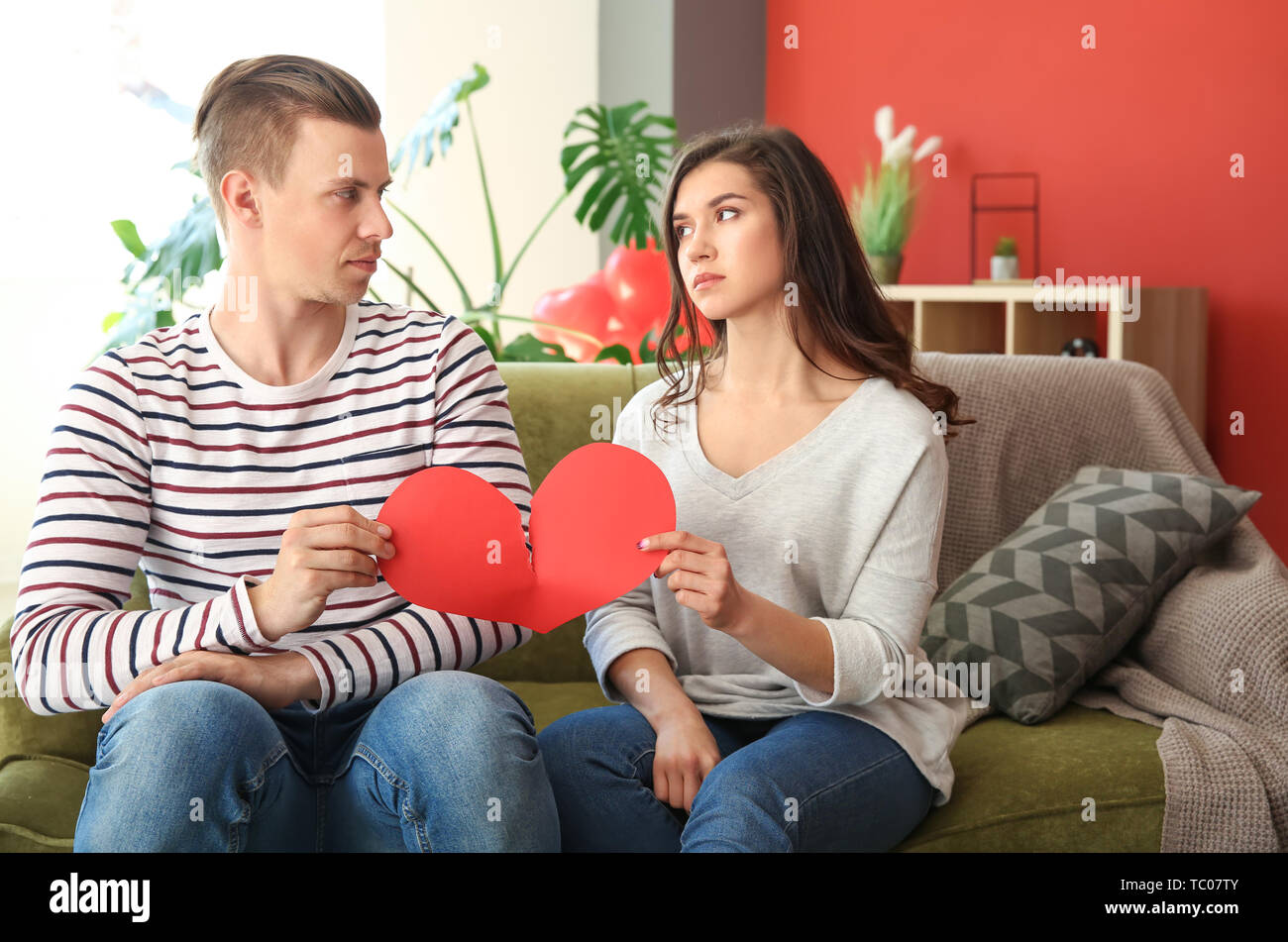 Jeune couple malheureux déchirement papier à la maison. Conflit en relation Banque D'Images