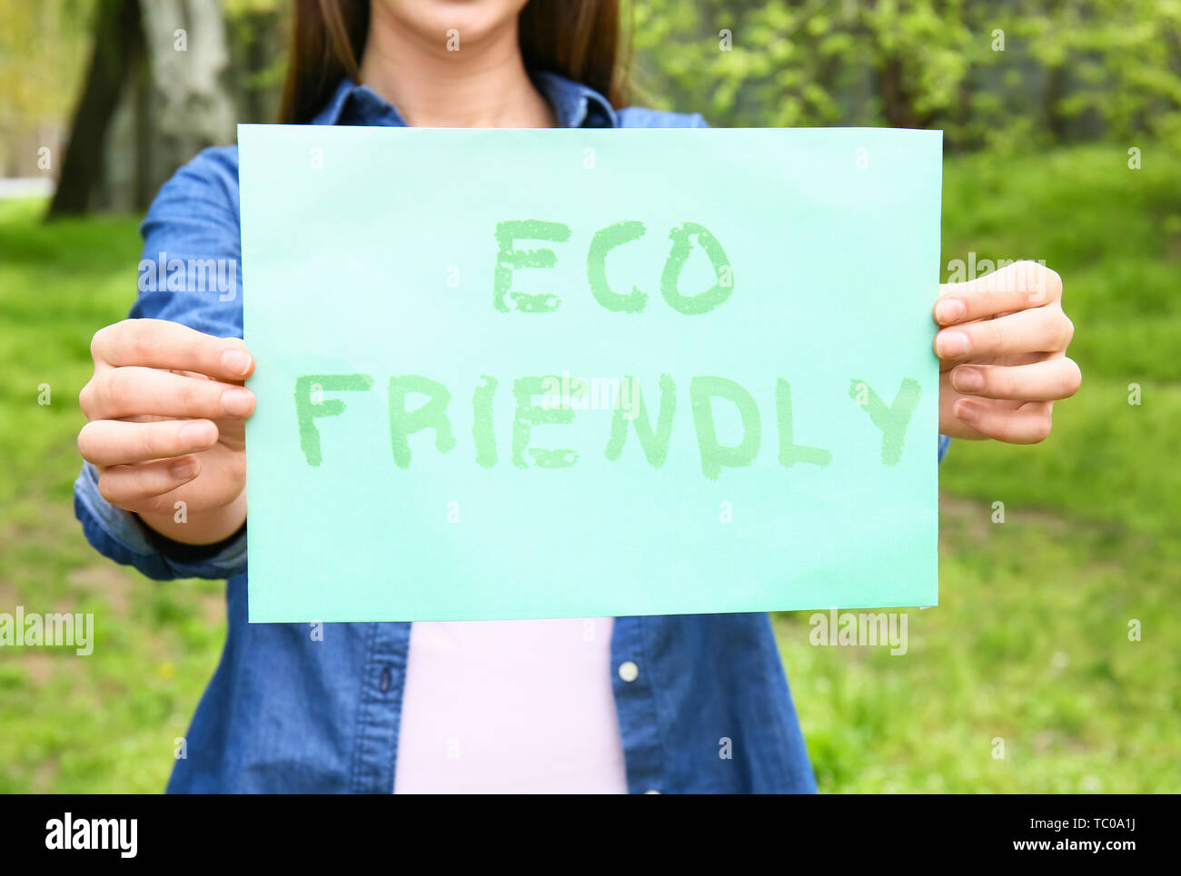 Woman holding feuille de papier avec texte ECO FRIENDLY outdoors Banque D'Images