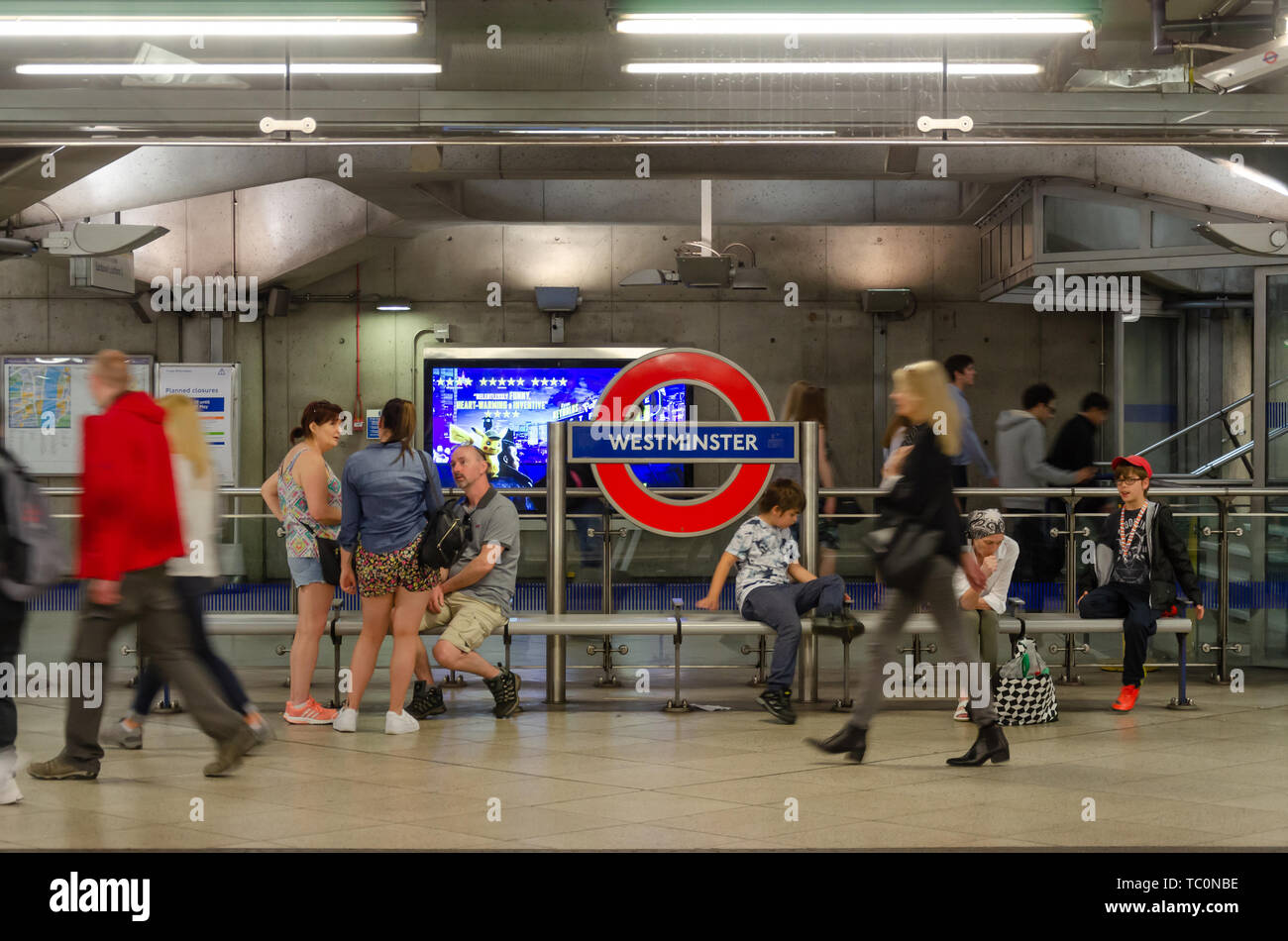 Les gens s'asseoir sur un banc sur la plate-forme à la station de métro Westminster Banque D'Images