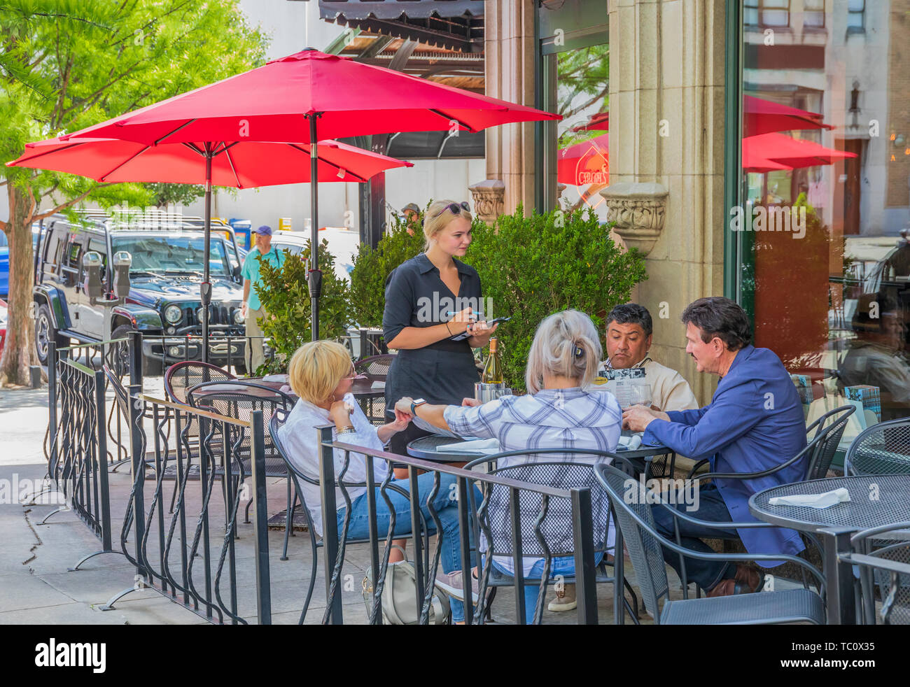 ASHEVILLE, NC, USA-5/31/19 : Deux couples assis à l'extérieur table de restaurant, avec waitress. Le restaurant du Carmel à la page Ave. Banque D'Images