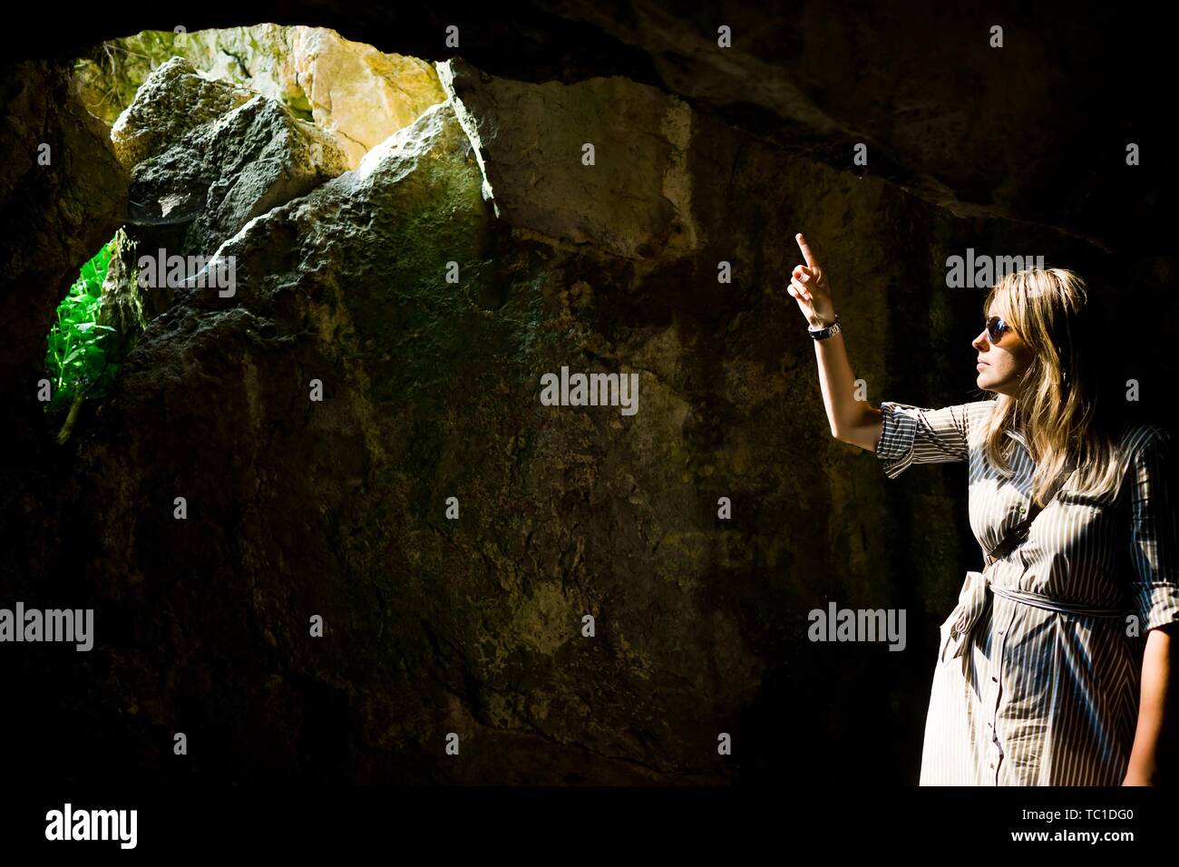 Woman pointing et trou dans l'ancienne cave où le soleil va à l'intérieur Banque D'Images