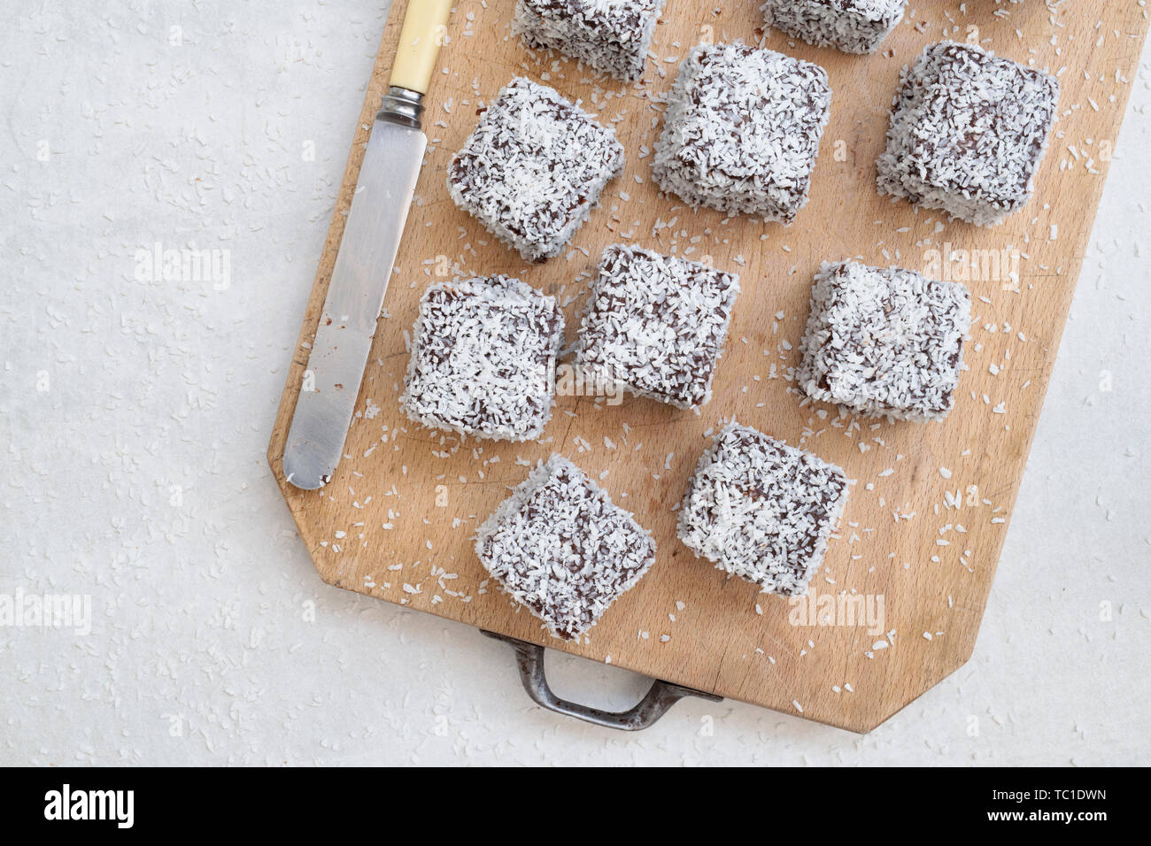 Des gâteaux de Lamington. Gâteau d'Australie. Gâteau éponge coupé en cubes enrobés d'une couche de sauce au chocolat et roulé dans la noix de coco desséchée Banque D'Images