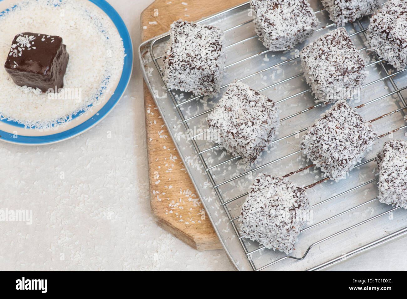 Des gâteaux de Lamington. Gâteau d'Australie. Gâteau éponge coupé en cubes enrobés d'une couche de sauce au chocolat et roulé dans la noix de coco desséchée Banque D'Images