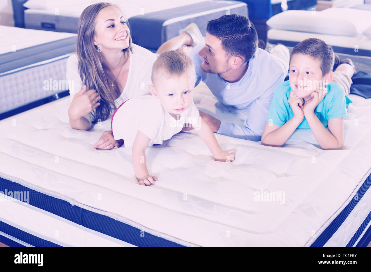 Petit Client Espagnol Positive Avec Sa Famille Heureuse Le Choix De Matelas Droit En Magasin D Accessoires De Maison Photo Stock Alamy