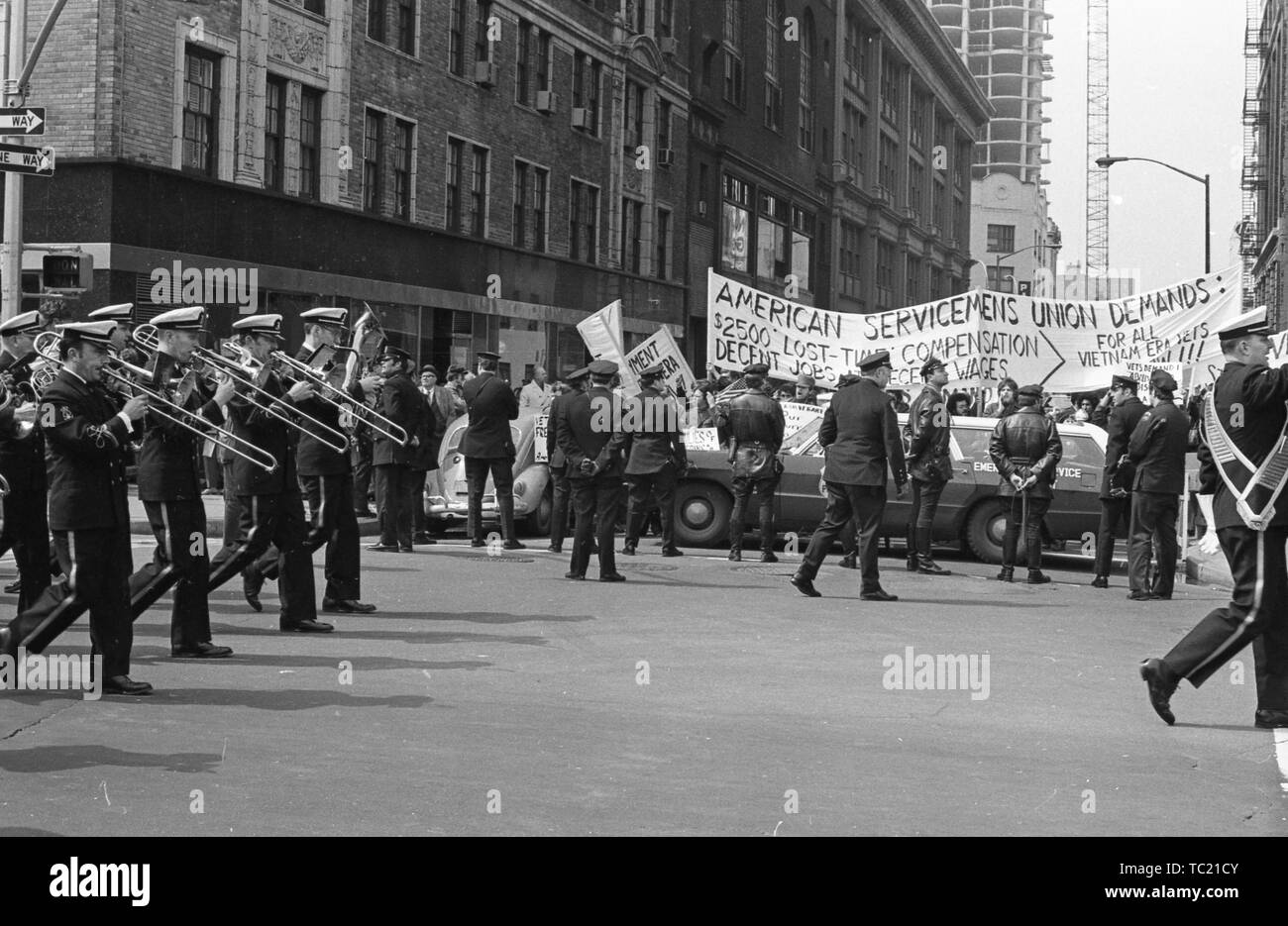 Une fanfare passe un groupe de policier, de l'arrière, blocage d'une rangée de soldats américains's Union les manifestants pendant la guerre du Vietnam Accueil liées à l'honneur Avec Parade, New York City, New York, mars 31, 1973. () Banque D'Images