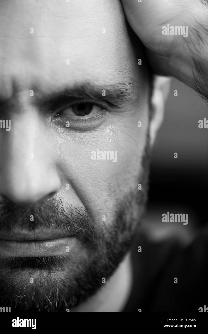 Portrait noir et blanc de pleurer barbu man looking at camera Banque D'Images