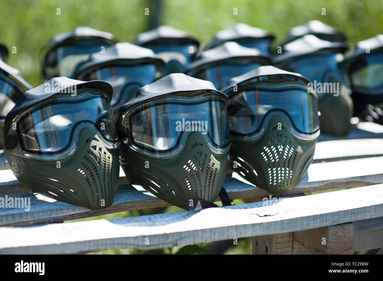 Masque de protection spécial pour jouer au paintball avec des traces et le point de frappe d'un ballon avec de la peinture. Équipement pour jouer au paintball sur une table en bois Banque D'Images