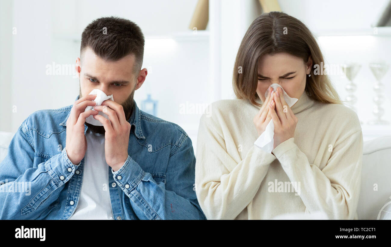 Concept de la grippe. Nez de soufflage couple dans les tissus à la maison Banque D'Images