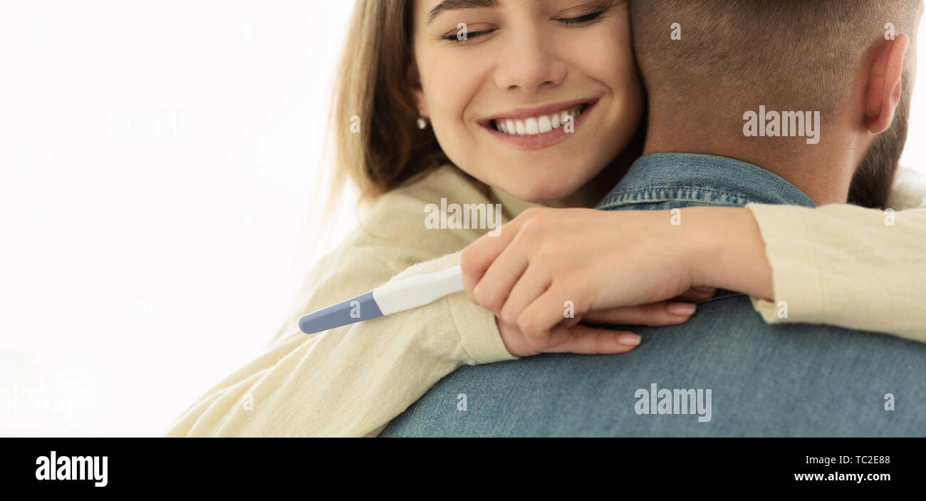 Heureux Couple Hugging avec test de grossesse positif Banque D'Images