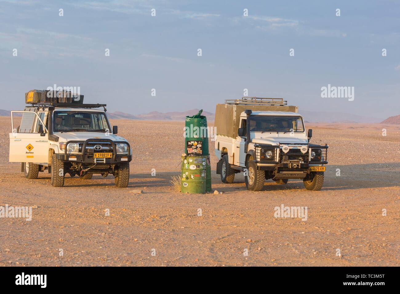 Deux véhicules 4x4 au tambour vert waypoint, paysage désertique, la Namibie, le Kaokoveld Banque D'Images