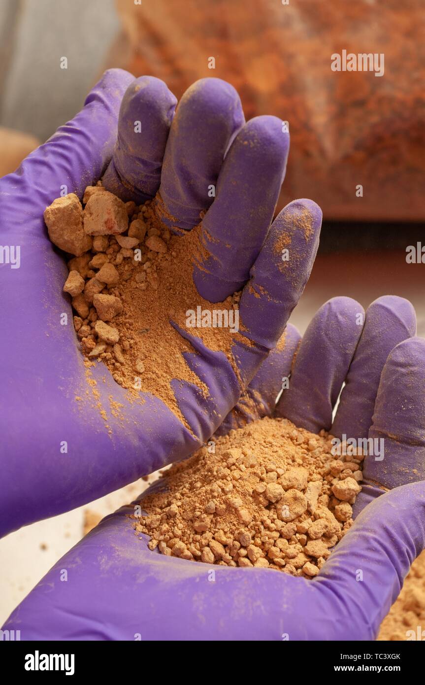Close-up de l'ocre du sable coloré ou de sédiments, en violet les mains gantées, dans un laboratoire de sciences de la Terre et des planètes de l'Université Johns Hopkins, Baltimore, Maryland, le 28 septembre 2007. À partir de la collection photographique de Homewood. () Banque D'Images