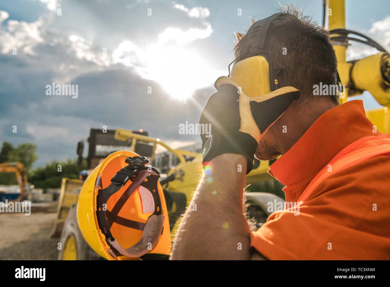 Le bruit de la construction. Opérateur de machinerie lourde avec réduction de bruit casque sur sa tête. Concept industriel. Banque D'Images