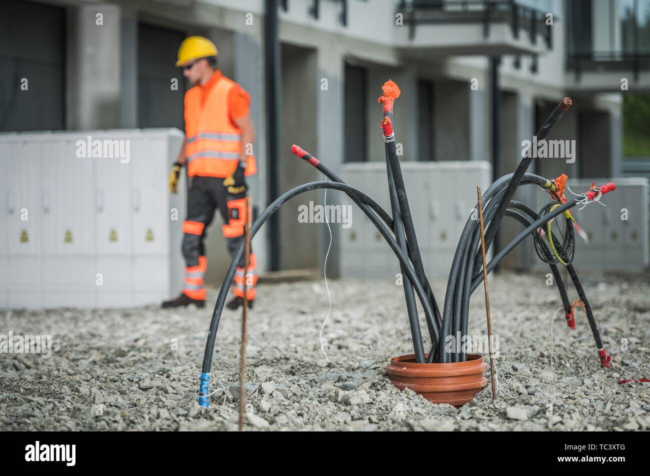 Câbles haute tension de l'installation. Bande de Comping Câbles de pipeline souterrain. Technicien électrique à l'arrière-plan. Banque D'Images