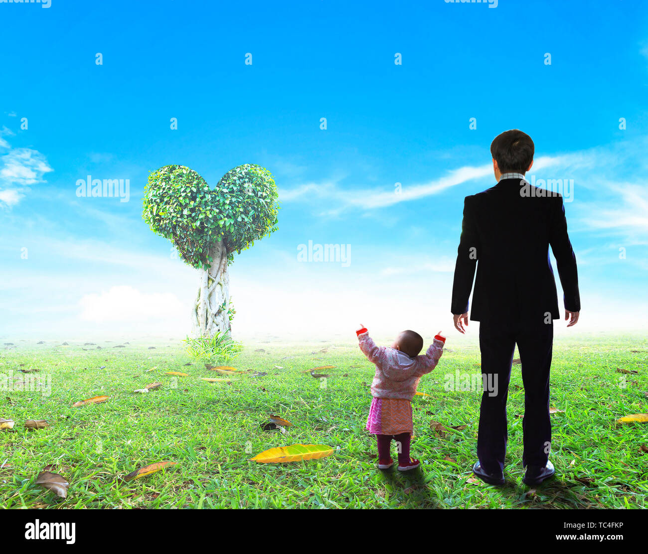 Concept de la Fête des pères : père et fille debout devant l'arbre en forme de coeur Banque D'Images