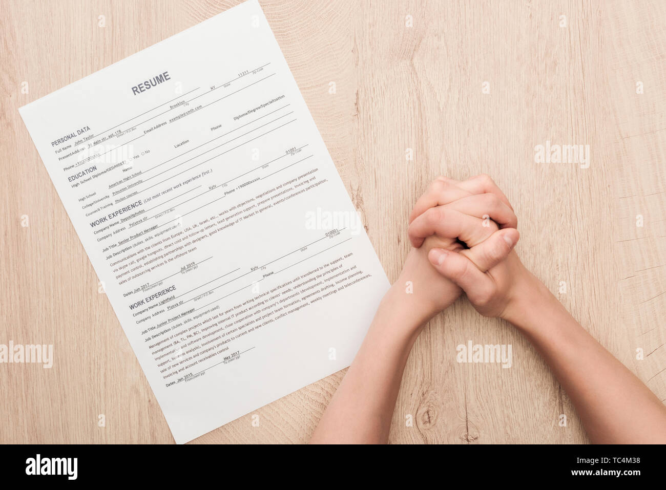 Portrait de recruteur holding serra les mains près de modèle de CV sur table en bois Banque D'Images