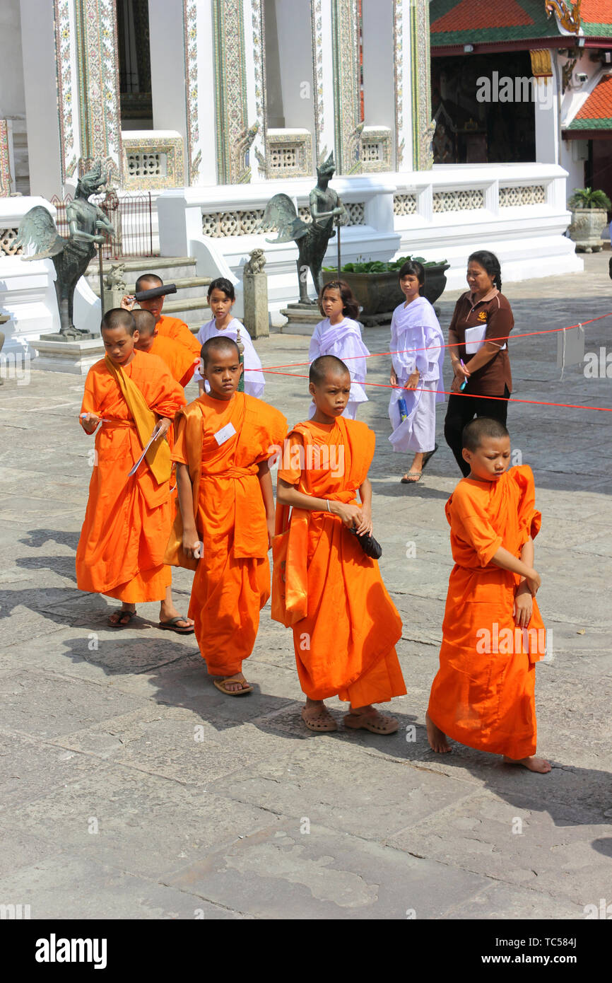 Groupe de moines asiatiques marche à travers le temple du Bouddha d'Émeraude en Thaïlande. Banque D'Images