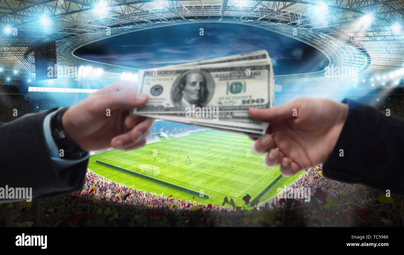 Transfert d'argent entre deux mains au stade de soccer Banque D'Images
