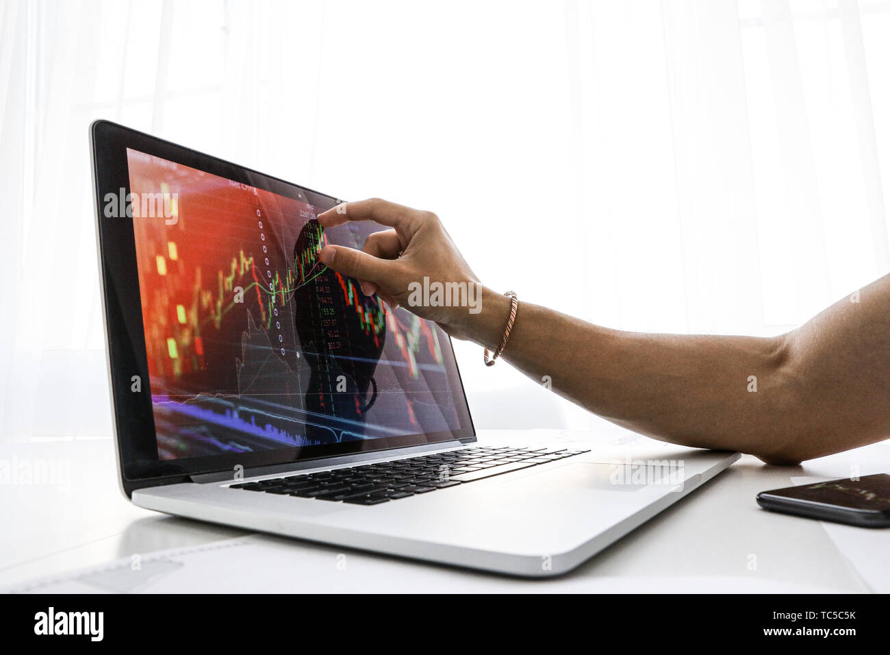 Businessman présente l'écran sur l'ordinateur portable le graphique de la croissance Banque D'Images