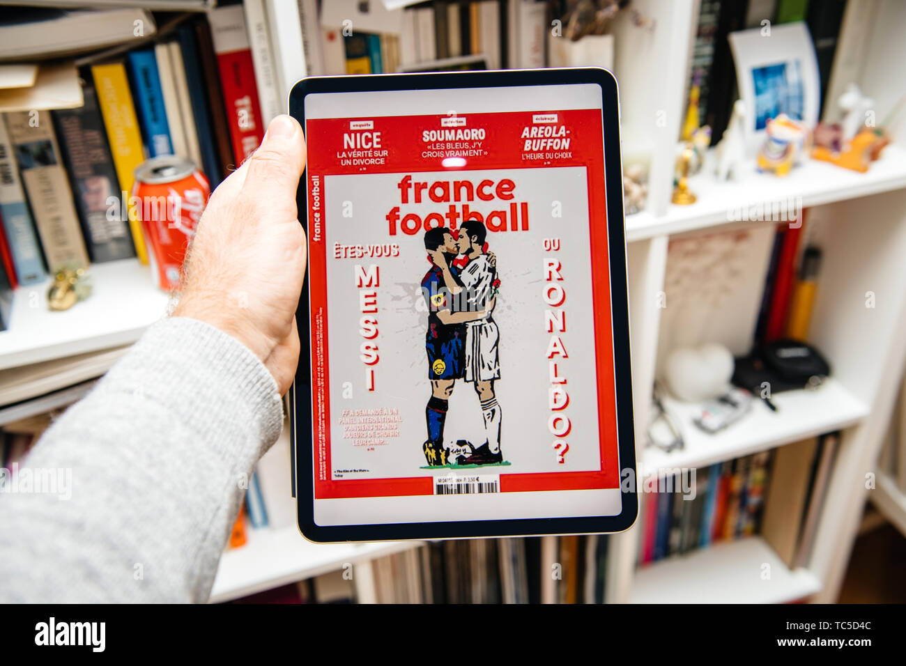 Paris, France - Apr 15, 2019 : lecture sur iPad Apple Pro News Plus d' journal numérique sur la couverture de France Football Messi et Ronaldo personnages de baisers Banque D'Images