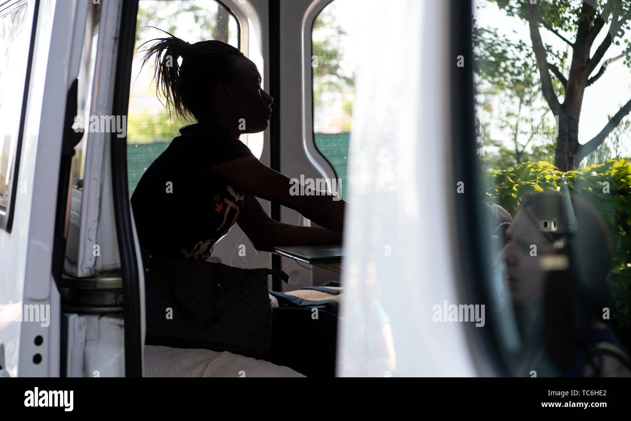 Munich, Allemagne. Le 05 juin, 2019. Une femme de l'Ouganda est assise sur un 'numéro Infobus pour les réfugiés' en face d'un abri et de réfugiés est conseillée par les employés de la Munich Refugee Council. L'exploitant de l'Infobus 'für Flüchtlinge 1933-1945', qui ensemble avec Amnesty International offre des conseils juridiques aux demandeurs d'asile, est l'introduction d'une action devant le tribunal administratif contre une décision prise par le gouvernement de Haute-bavière pour refuser l'accès à l'équipe consultative d'hébergement des réfugiés. Crédit : Sven Hoppe/dpa/Alamy Live News Banque D'Images