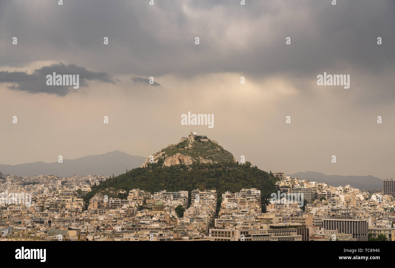 La colline de Lycabettus s'élève au-dessus à Athènes, le jour de tempête Banque D'Images
