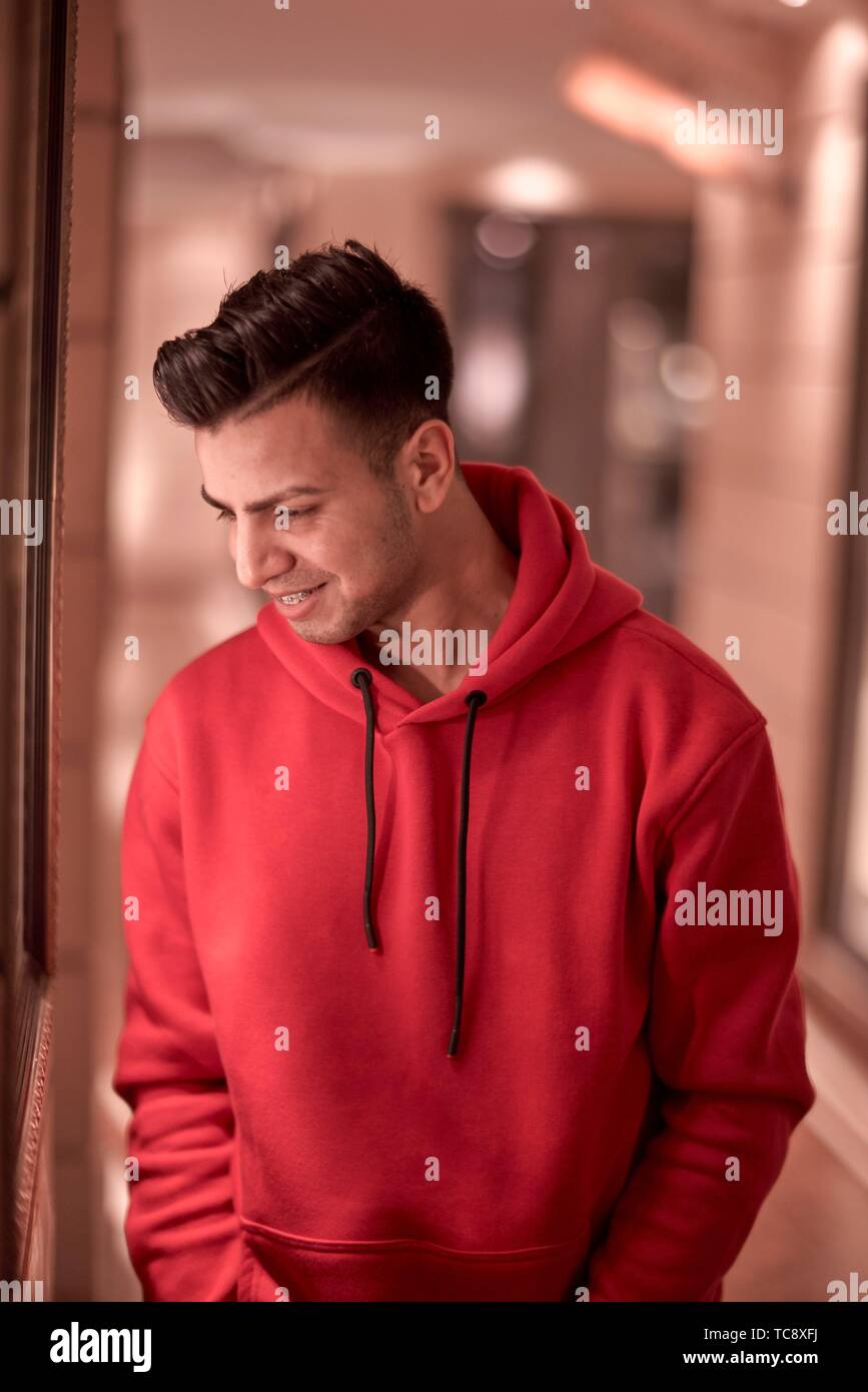 L'homme millénaire avec de confortables pull rouge pull à capuche à  l'intérieur, l'origine ethnique, de l'Afghanistan, à Munich, Allemagne  Photo Stock - Alamy