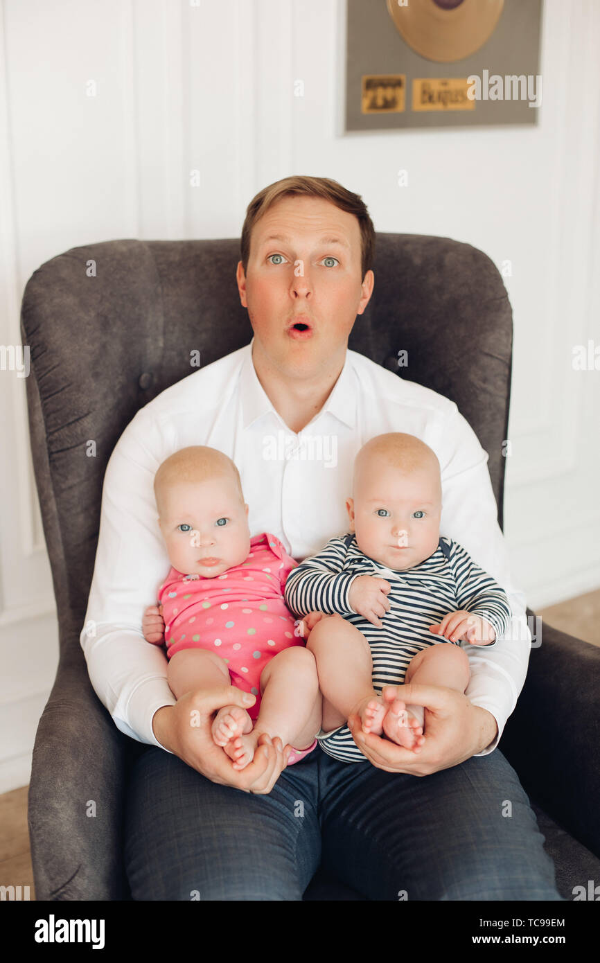 Funny Surpris Papa Avec Deux Bebes Sur Les Genoux Photo Stock Alamy