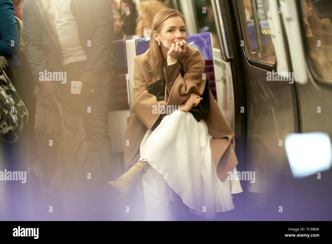 Blogger à la mode femme assise dans le métro, en utilisant les transports publics, au cours de la semaine de la mode, ville de Paris, France Banque D'Images