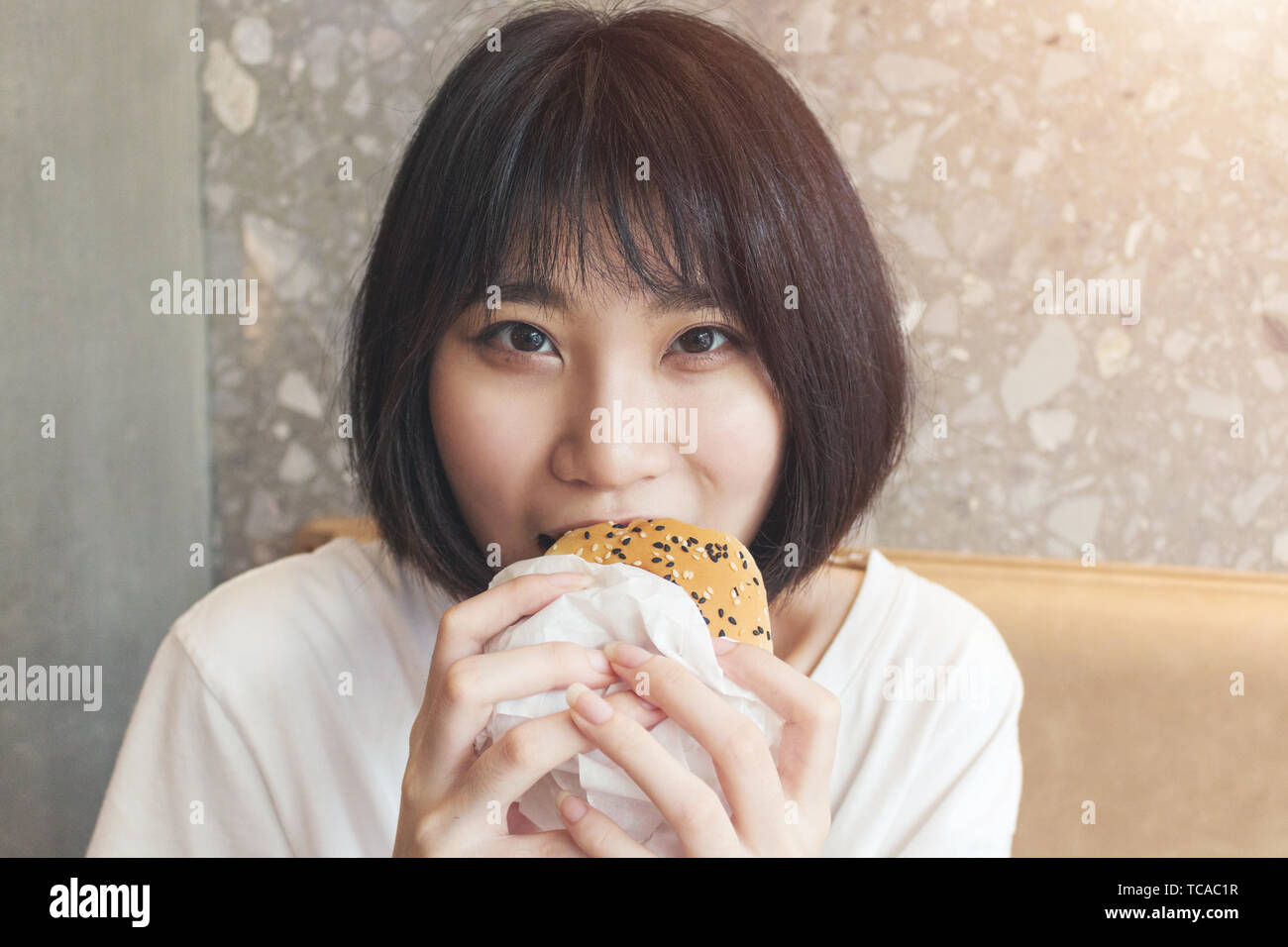 Close-up of girl biting hamburger Banque D'Images
