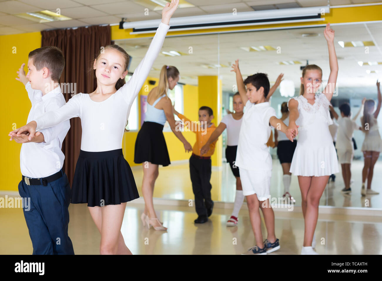 Smiling Children Dancing danse paire suisse en classe Banque D'Images