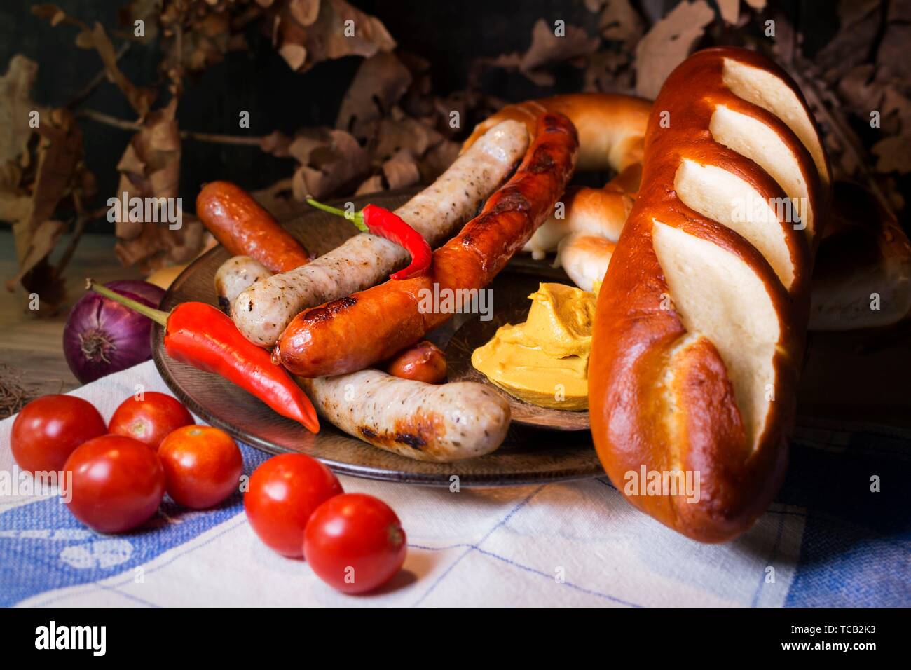 Blanc et Rouge Bavaroise saucisses avec de la moutarde, des brioches et des bretzels bavarois à la table. Octobre Fest Concept. Banque D'Images