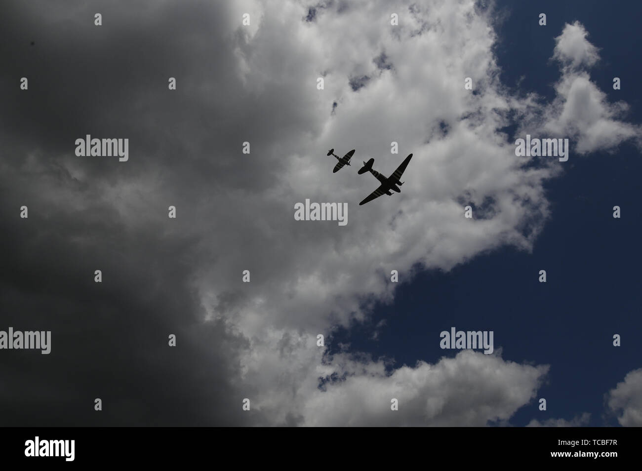 Un Dakota et un Spitfire faire un survol de la Commonwealth War Graves Commission Cemetery, à Bayeux, en France, à l'occasion du 75e anniversaire du débarquement. Banque D'Images