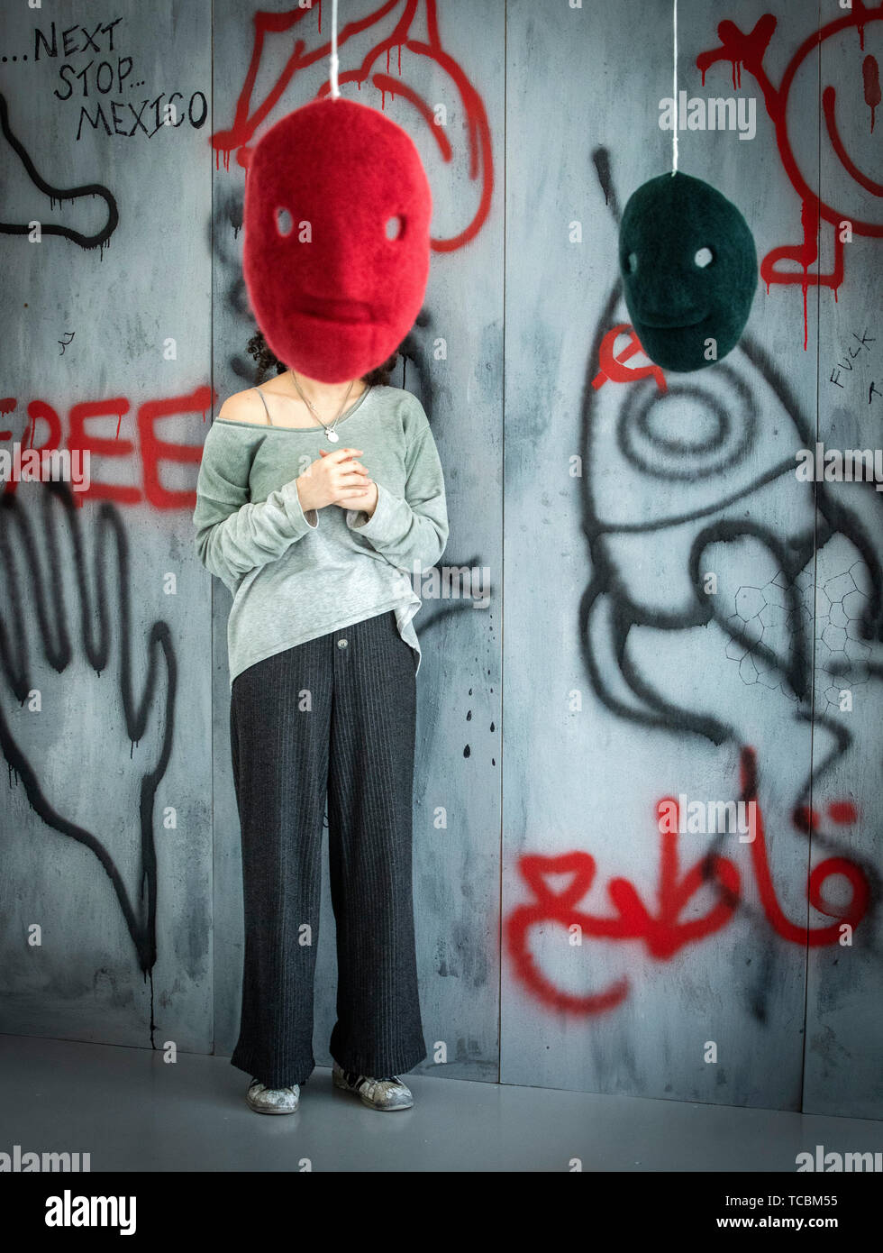 Un masque d'une œuvre intitulée La peur et l'ami de l'artiste Lucie Bowley obscurcit le visage de Mariam Shaath comme elle se tient en face de son travail intitulé seulement la terre le sait, tant les œuvres d'art font partie de l'art show degré à l'Université de Leeds. Banque D'Images