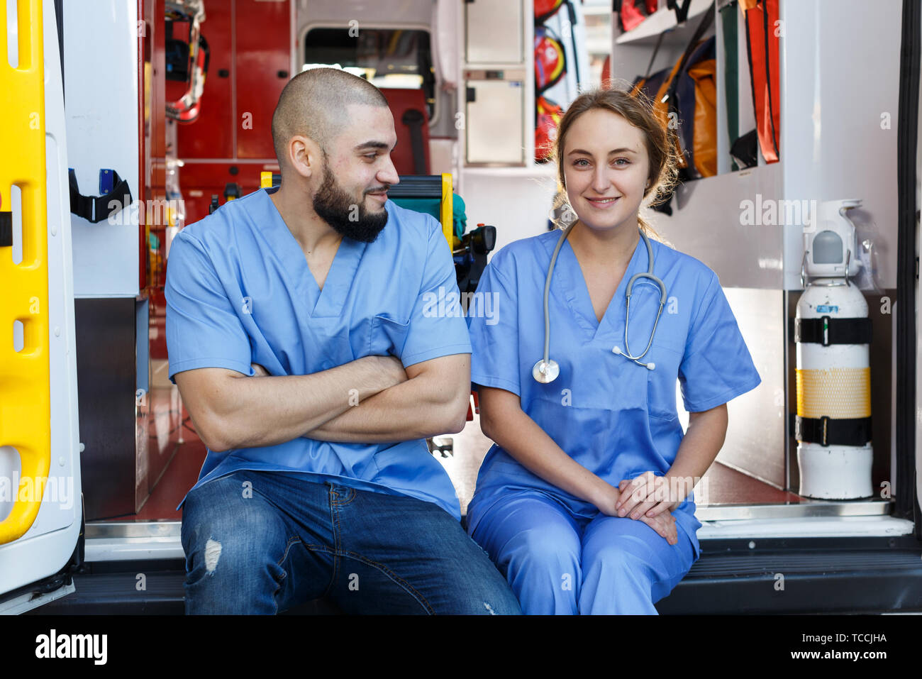 Portrait de deux ambulanciers positif assis en voiture ambulance Banque D'Images