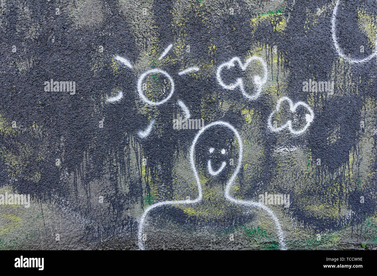 Pour l'encombrement d'un homme souriant avec Sun et les mottes dessiné sur le mur d'un bâtiment Banque D'Images